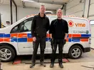 Två personer i verkstad framför vit VME-servicebil.